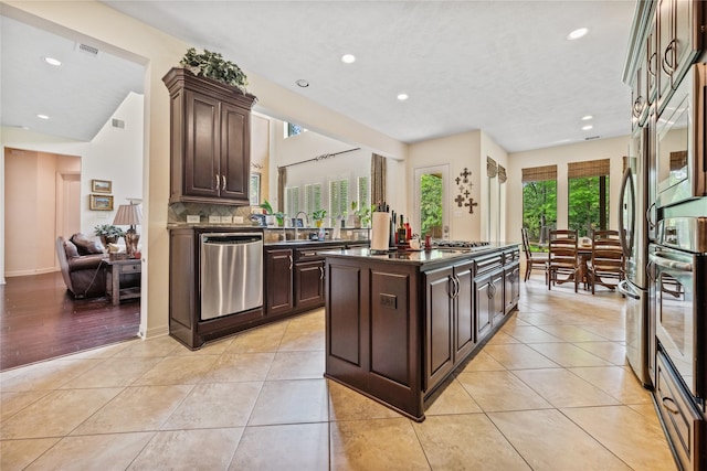 kitchen featuring recessed lighting, dark brown cabinetry, stainless steel appliances, and light tile patterned floors