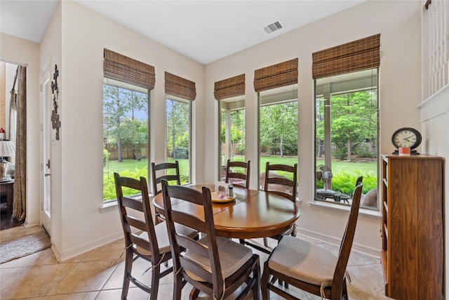 dining area featuring light tile patterned floors, baseboards, visible vents, and plenty of natural light