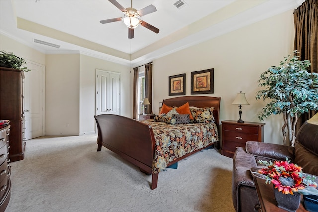 bedroom featuring crown molding, visible vents, carpet floors, and a tray ceiling