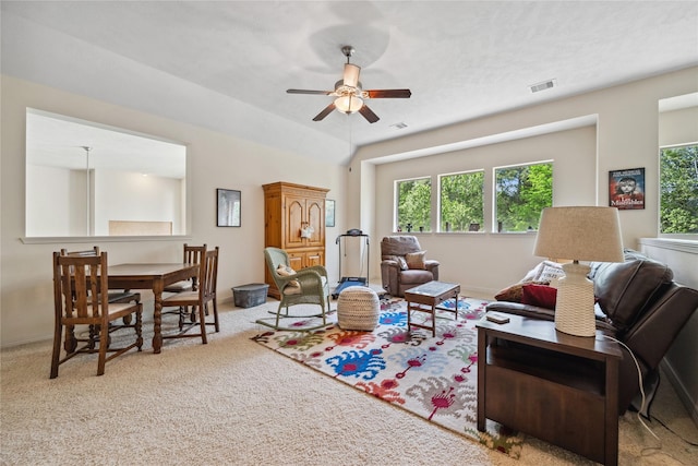 living area featuring carpet flooring, a ceiling fan, and visible vents