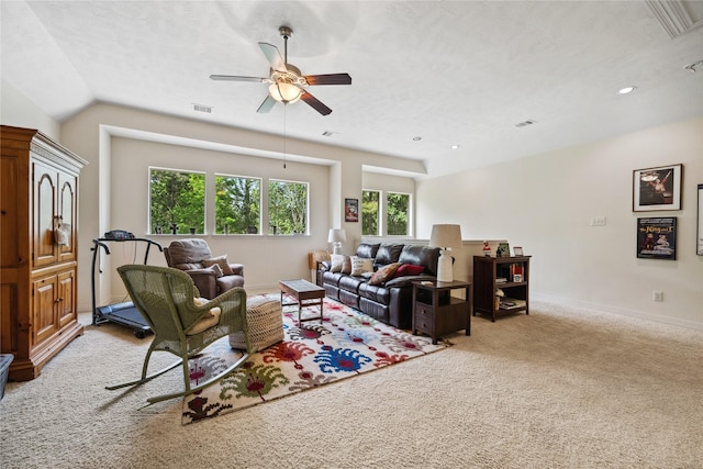 living room with baseboards, visible vents, light colored carpet, lofted ceiling, and a ceiling fan