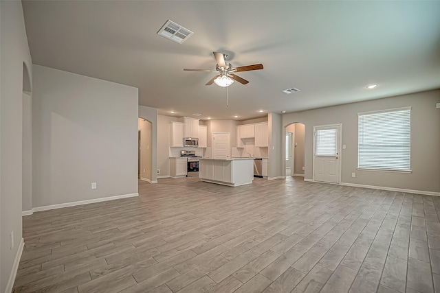 2128 Port Jackson, Texas City, TX 77568 - unfurnished living room featuring arched walkways, ceiling fan, light wood-style floors, baseboards, and recessed lighting