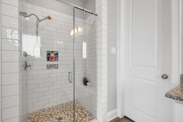 full bath with a shower stall and baseboards