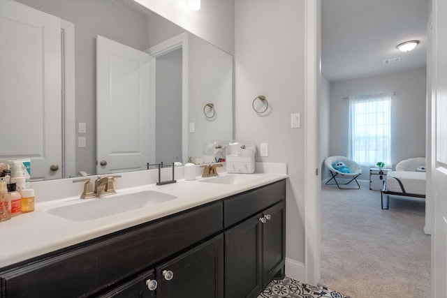 full bath featuring double vanity, visible vents, baseboards, and a sink