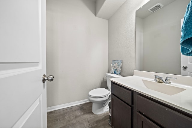 32610 Dew Crest St, Brookshire, TX 77423 - half bathroom featuring wood tiled floor, vanity, baseboards, toilet, and visible vents