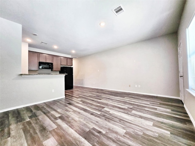 unfurnished living room with baseboards, wood finished floors, visible vents, and recessed lighting