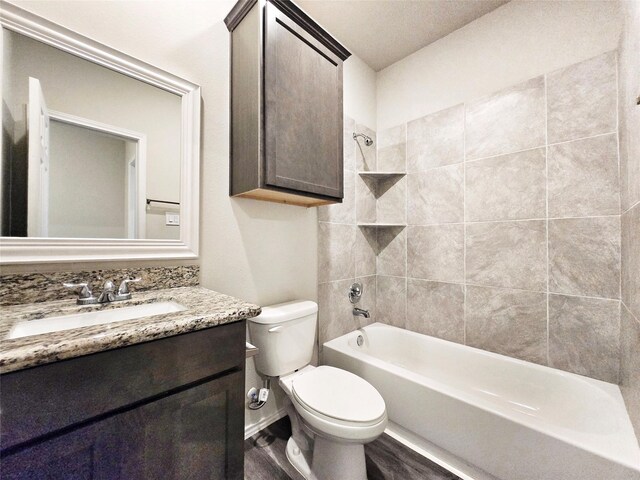 bathroom with wood finished floors, toilet, vanity, and  shower combination