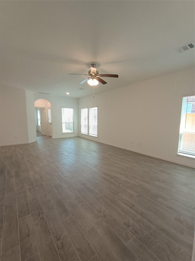 12367 Sterling Oak, Humble, TX 77044 - unfurnished living room featuring ceiling fan, dark wood finished floors, arched walkways, and baseboards