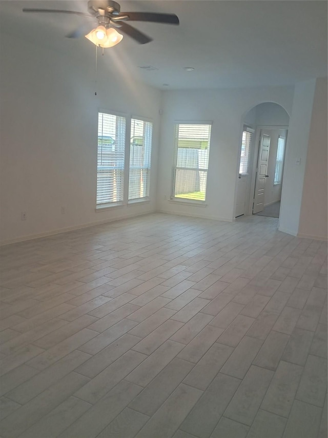 12367 Sterling Oak, Humble, TX 77044 - spare room with arched walkways, healthy amount of natural light, a ceiling fan, and baseboards