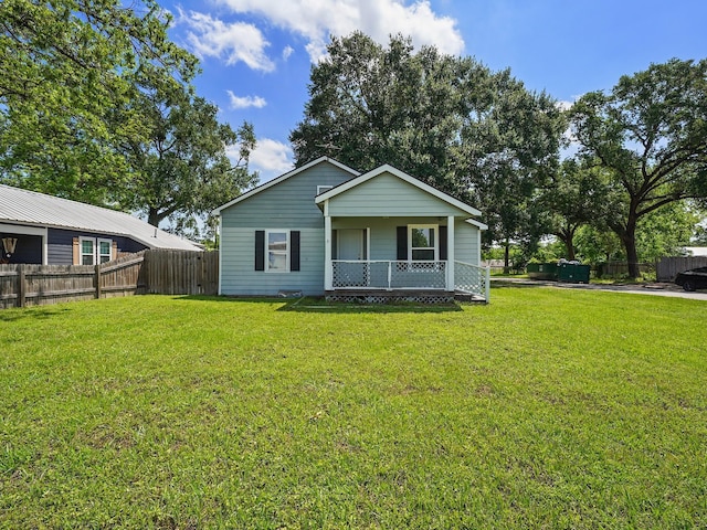 view of front of home featuring covered porch, fence, and a front yard