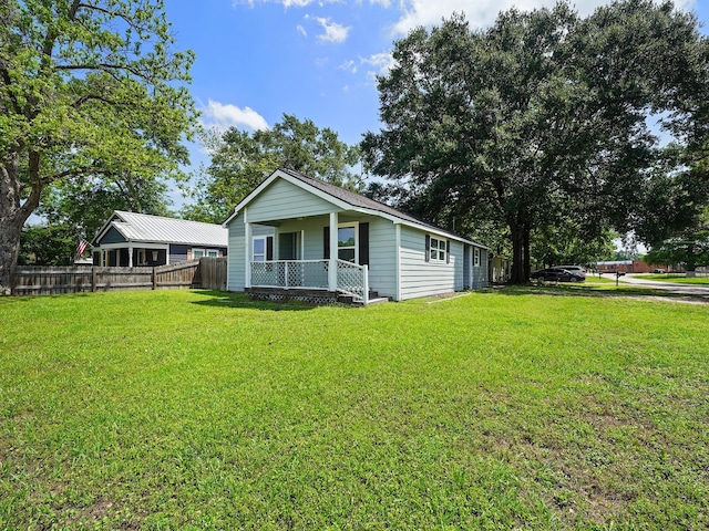 view of front of property featuring a porch, a front lawn, and fence