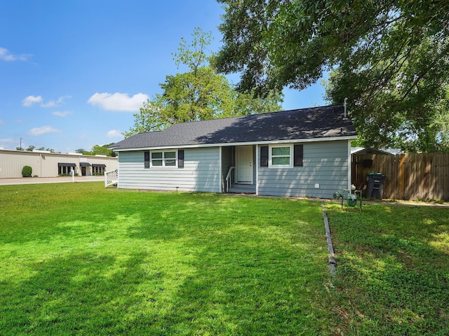 view of front of home with a front yard and fence