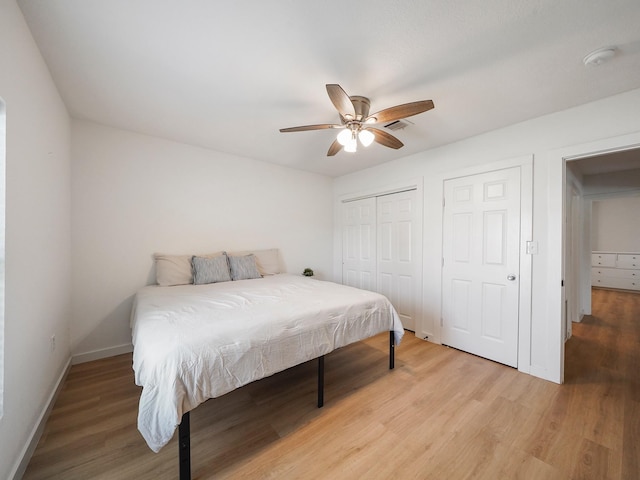 bedroom with visible vents, ceiling fan, a closet, baseboards, and light wood finished floors