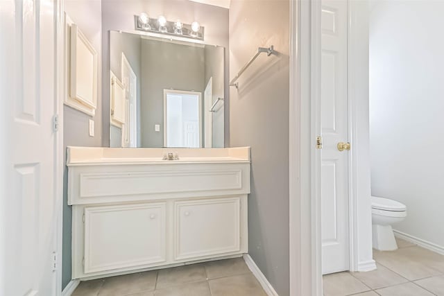 bathroom with baseboards, tile patterned floors, vanity, and toilet