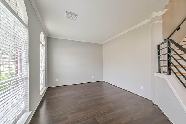unfurnished room with wood finished floors, visible vents, stairs, and ornamental molding