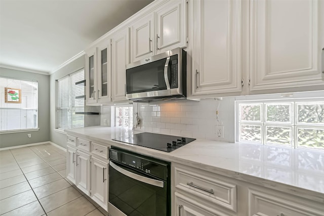 kitchen with white cabinets, black electric cooktop, wall oven, stainless steel microwave, and decorative backsplash