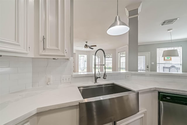 kitchen with white cabinets, a sink, visible vents, backsplash, and hanging light fixtures