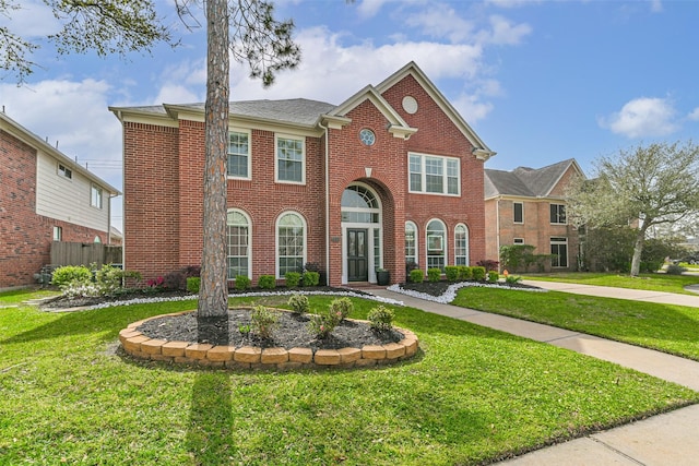 view of front of property with fence, a front lawn, and brick siding