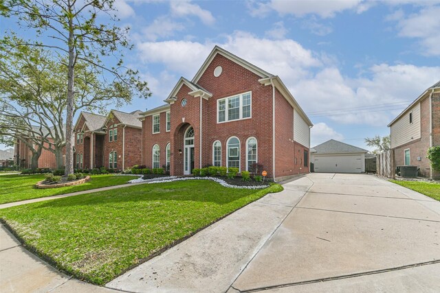 view of front of property featuring central AC, a detached garage, a front lawn, an outdoor structure, and brick siding