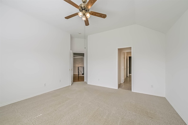 unfurnished bedroom with vaulted ceiling, baseboards, and light carpet