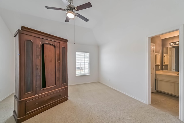 unfurnished bedroom with vaulted ceiling, a ceiling fan, ensuite bathroom, light colored carpet, and baseboards