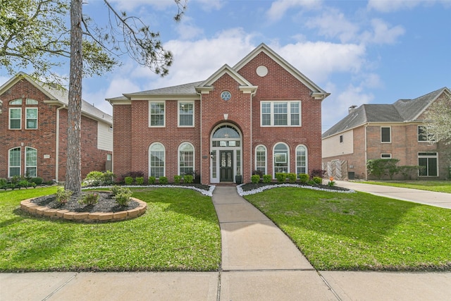 view of front facade featuring brick siding and a front yard