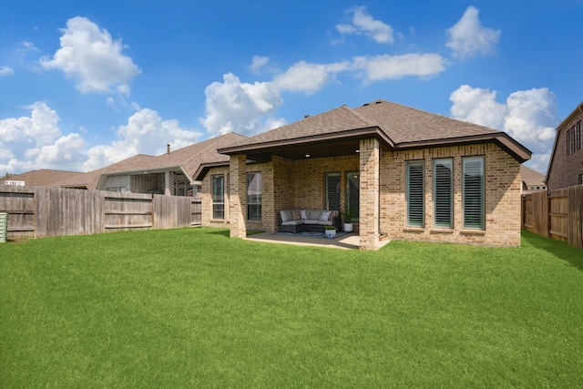 back of property featuring outdoor lounge area, a fenced backyard, brick siding, a patio area, and a lawn
