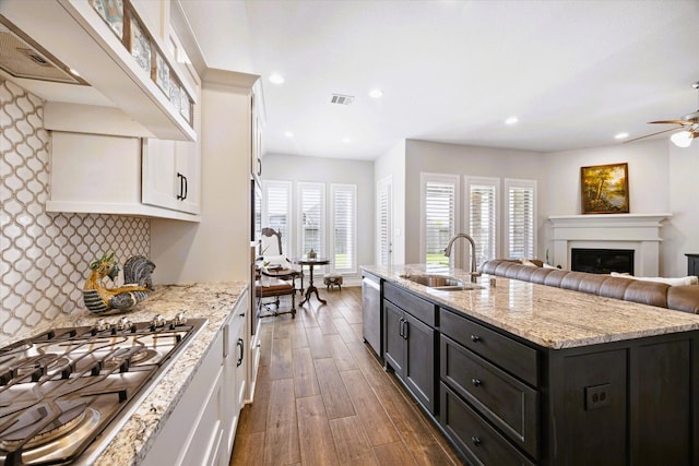 kitchen featuring stainless steel appliances, white cabinetry, a sink, and wood finished floors