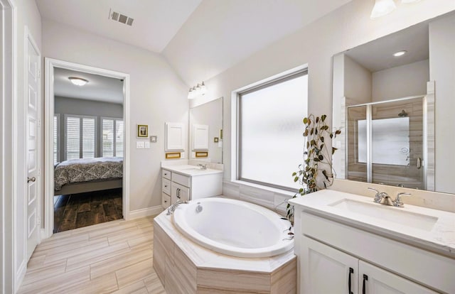 ensuite bathroom featuring visible vents, a shower stall, a sink, and a bath