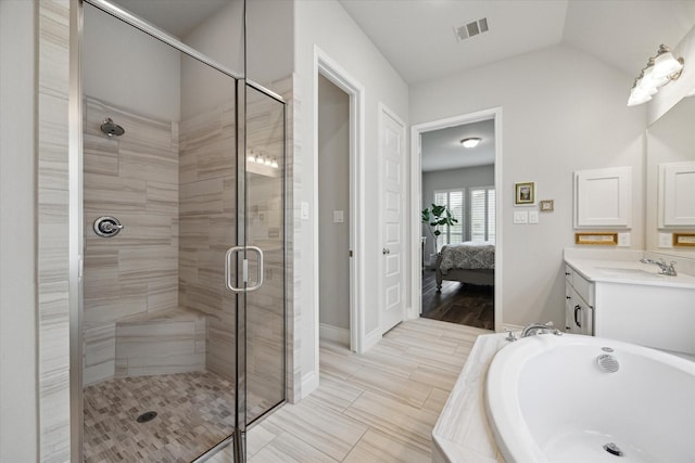 bathroom with a bath, visible vents, a stall shower, vanity, and ensuite bath