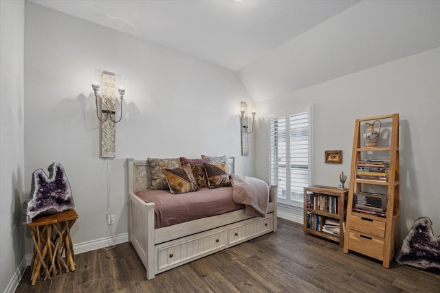 bedroom with baseboards, vaulted ceiling, and wood finished floors