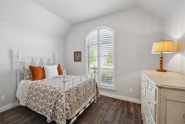 bedroom with baseboards, vaulted ceiling, and dark wood-style floors