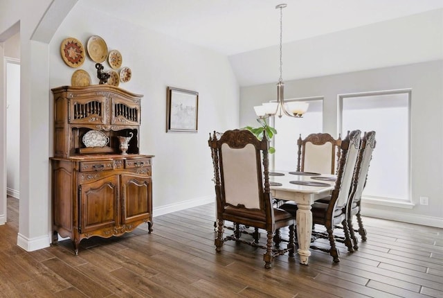 dining space with arched walkways, a notable chandelier, baseboards, dark wood-style floors, and lofted ceiling