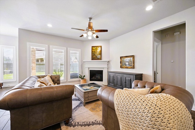 living room with recessed lighting, ceiling fan, and a glass covered fireplace