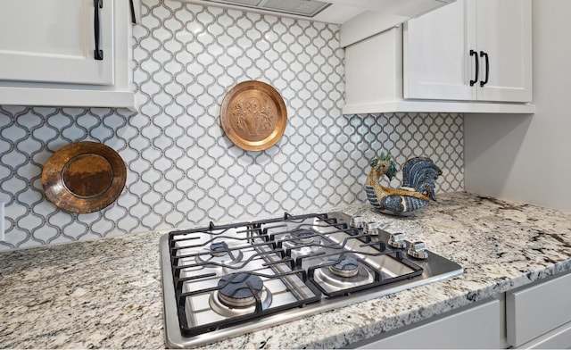 kitchen featuring white cabinetry, stainless steel gas cooktop, and light stone countertops