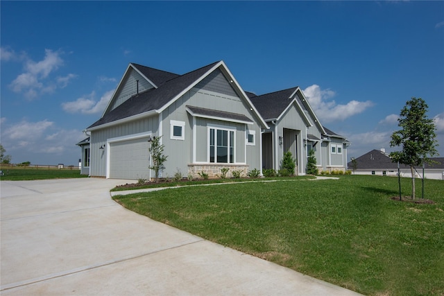 craftsman inspired home featuring board and batten siding, a front yard, and concrete driveway