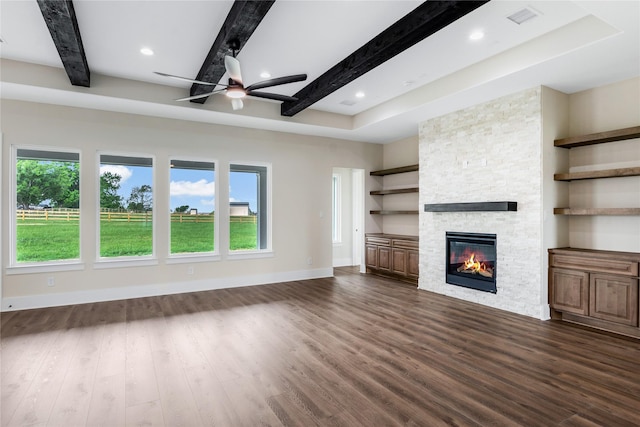 unfurnished living room featuring a wealth of natural light, baseboards, beam ceiling, and dark wood-style flooring