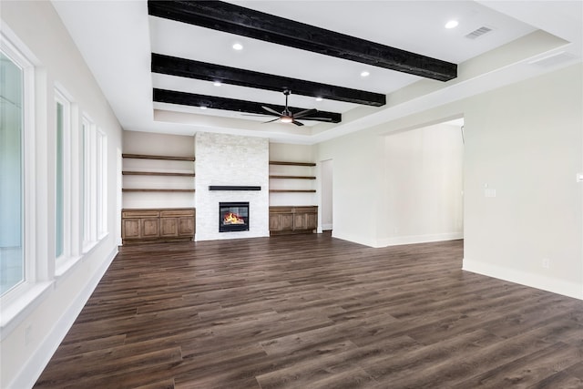 unfurnished living room with dark wood-style flooring, visible vents, beamed ceiling, a ceiling fan, and a fireplace