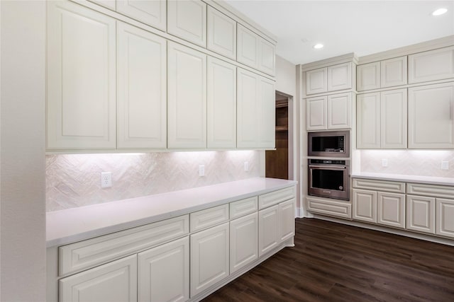 kitchen featuring built in microwave, light countertops, oven, and dark wood-style floors