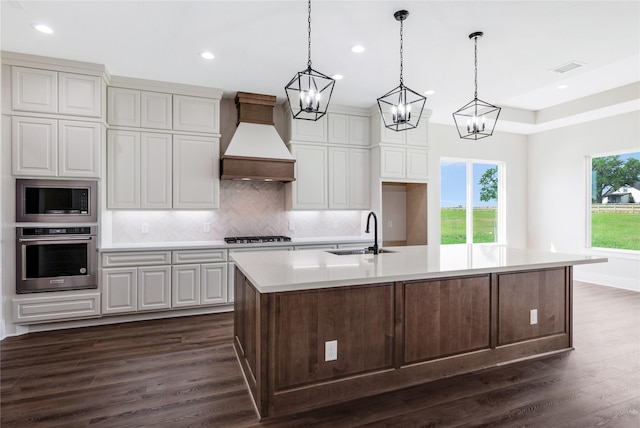 kitchen featuring built in microwave, dark wood-style floors, a sink, stainless steel oven, and custom exhaust hood