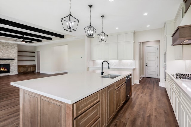 kitchen featuring dark wood-style floors, a sink, beamed ceiling, ceiling fan with notable chandelier, and custom range hood