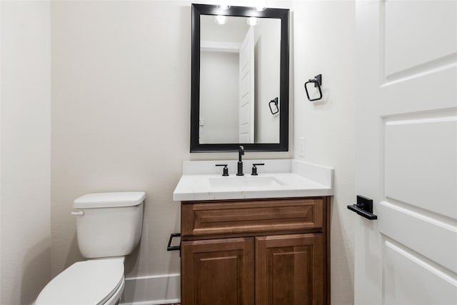 half bath featuring toilet and vanity