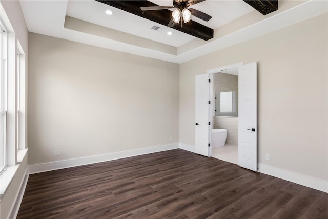 unfurnished bedroom featuring connected bathroom, dark wood finished floors, baseboards, and visible vents