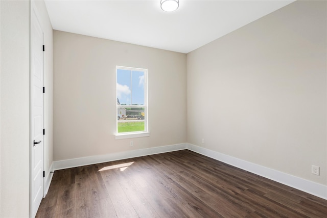 empty room with dark wood finished floors and baseboards