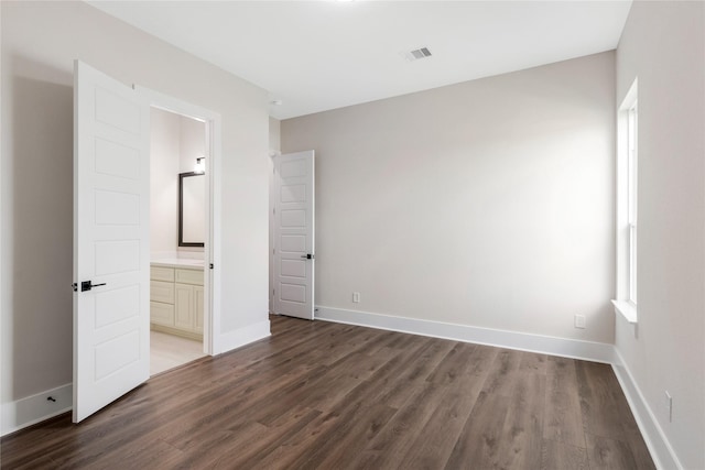 unfurnished bedroom featuring baseboards, wood finished floors, and visible vents
