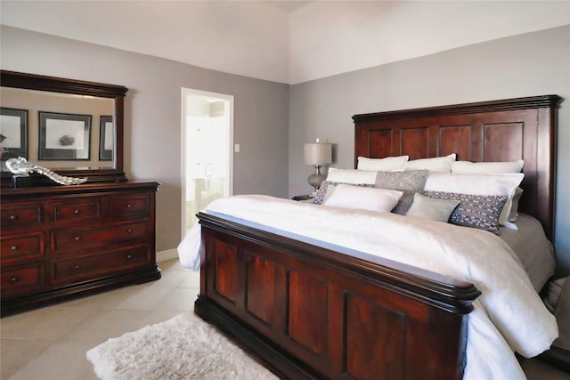 bedroom with light tile patterned floors, connected bathroom, and baseboards