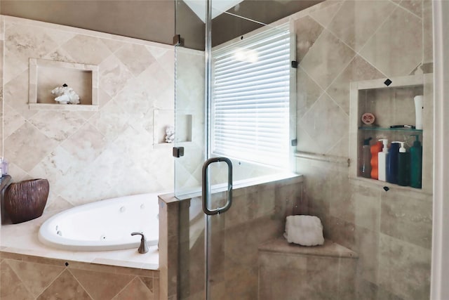 full bath featuring a shower stall, a tub with jets, and tile walls