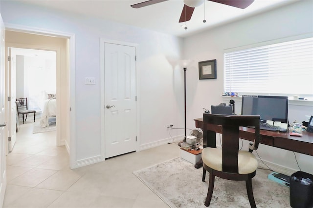 office space with a ceiling fan and baseboards