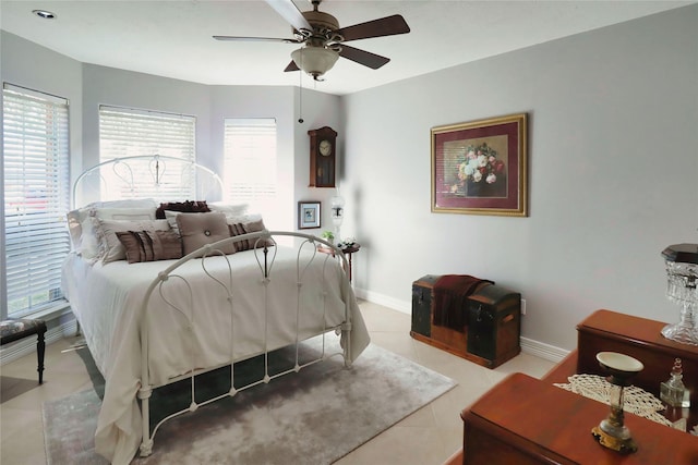 bedroom with multiple windows, baseboards, light tile patterned flooring, and a ceiling fan