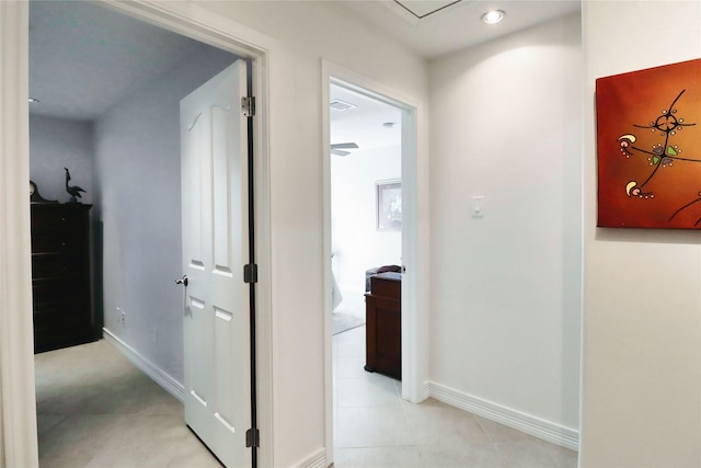 hall with baseboards and light tile patterned floors
